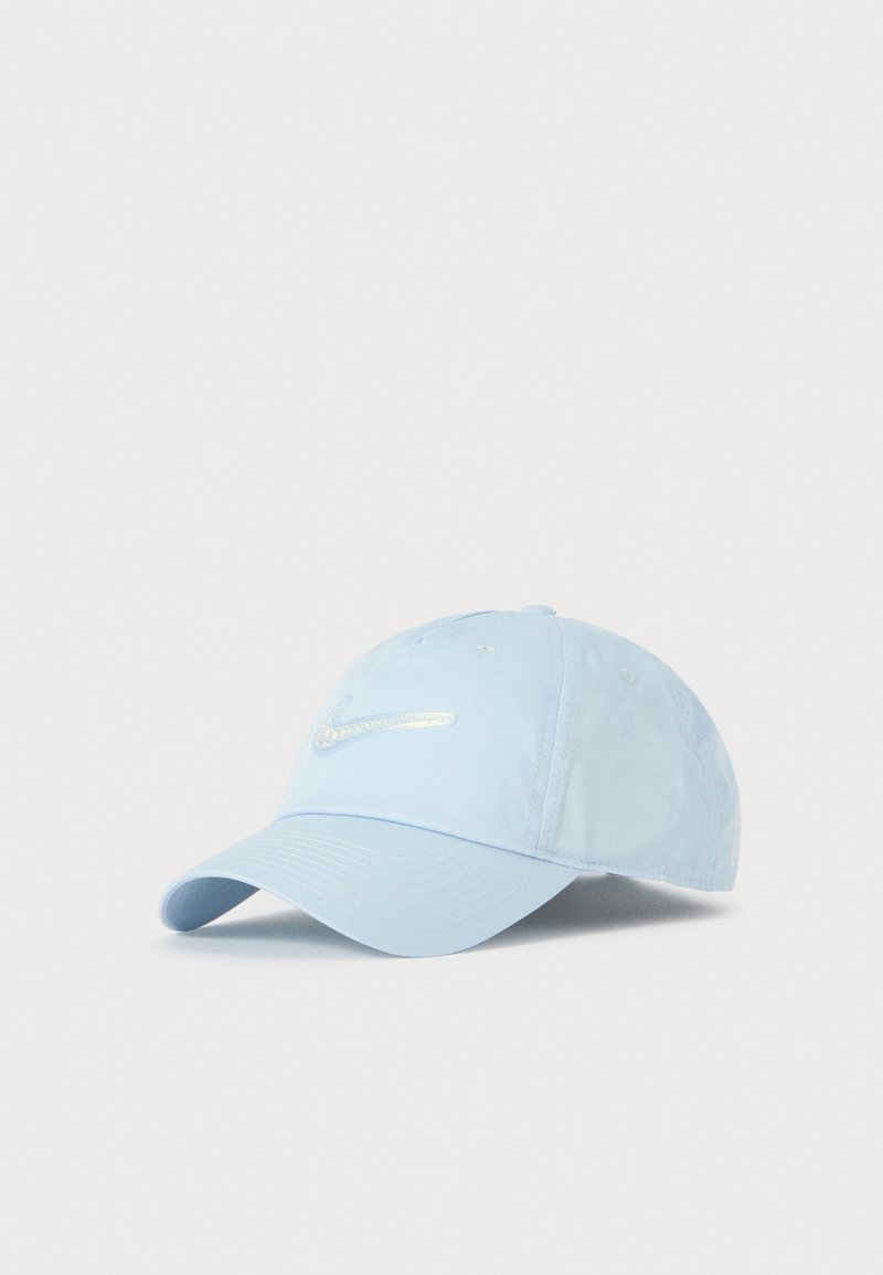 Svetlomodrá bejzbalová čiapka Nike s ohnutým vrchom a reflexnou logom Nike swoosh na prednej strane, umiestnená na jednom farebnom pozadí.