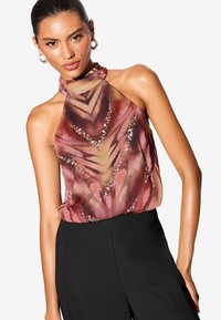 Top senza maniche a fascia con un motivo astratto rosa e marrone, dotato di paillettes e un scollo trasparente. Abbinato a pantaloni neri.