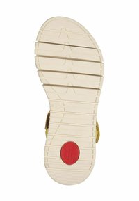 Parte inferiore di una scarpa con una suola texturizzata di colore crema con righe, un accento circolare rosso con la scritta "Comfort" e la taglia "37."