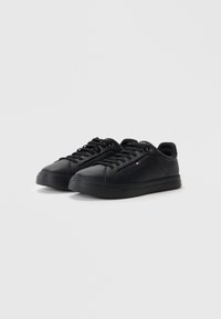 Czarne skórzane sneakersy o gładkiej fakturze, okrągłym czubku i płaskiej gumowej podeszwie. Posiadają sznurowane zapięcie i mały detal logo z boku.