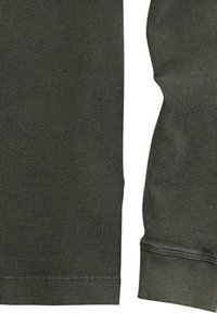 Dunkelgrünes, strukturiertes Kleidungsstück aus geripptem Stoff mit enganliegenden Bündchen und einfachem Design. Der Stoff wirkt robust und vielseitig einsetzbar.