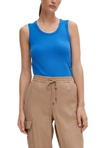 Top blu ribbed senza maniche con scollatura rotonda, abbinato a pantaloni beige chiaro con vita elastica, dotati di tasca cargo e coulisse.