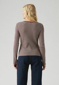 Langere mouwtop met een aansluitend ontwerp, met een bordeauxrood en wit gestreept patroon, gemaakt van zacht materiaal, met een ronde hals en ribbelstructuur.