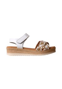 Sandale à plateforme blanche et beige avec des brides tressées à l’avant, une bride en Velcro à la cheville et une semelle intermédiaire en jute tissée sur fond blanc.