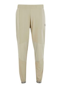 Beżowe spodnie z elastycznym pasem i zwężanymi nogawkami, wykonane z lekkiego materiału. Posiadają wzór w blokach kolorystycznych oraz logo z boku, ściągacze z prążkowanej tkaniny.