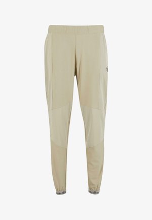 Beige kalhoty na gumu v pase s zúženými nohavicemi, vyrobené z lehkého materiálu. Obsahují design s blokováním barev a logo na boku, s žebrovanými manžetami.