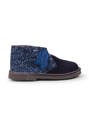 Stivaletti alla caviglia blu navy con un pannello posteriore glitterato e paillettato, un fiocco laterale e una suola in gomma. Materiale frontale morbido simile al camoscio.