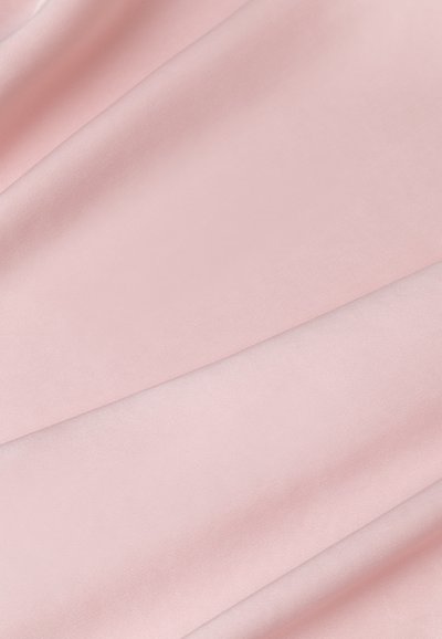 Puhaszatén rózsaszín anyag sima textúrával, finom fényességgel és lágy eséssel, egymásra hajtott redőkben elrendezve.