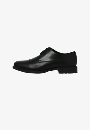 Chaussure formelle oxford pour hommes en cuir noir avec bout rapporté et laçage fermé, présentée de profil sur fond blanc.