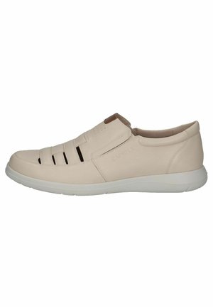 Beige leren instap schoenen met uitsneden aan de zijkanten en een witte rubberen zool. Heeft een bruine accenten bij de hiel. Gladde textuur.