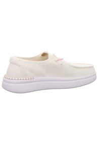 Bateau slip-on en toile blanche avec un bout rond, accent rose près des lacets, couture beige sur la semelle extérieure et une tige texturée.