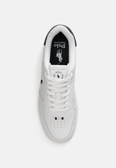 White sneaker with smooth leather upper, round toe, and flat laces. Black logo on tongue and side. Cushioned collar and perforated toe for breathability.