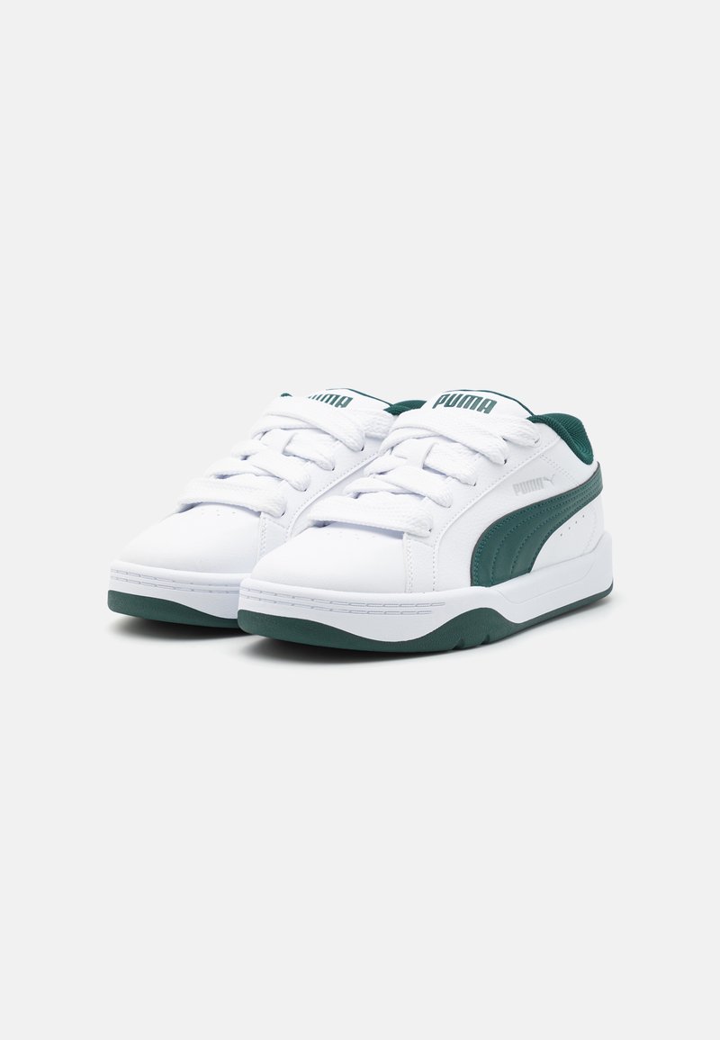 Zapatillas blancas de material sintético con acentos verdes, que presentan un diseño de corte bajo, punta redondeada y suela de goma plana.