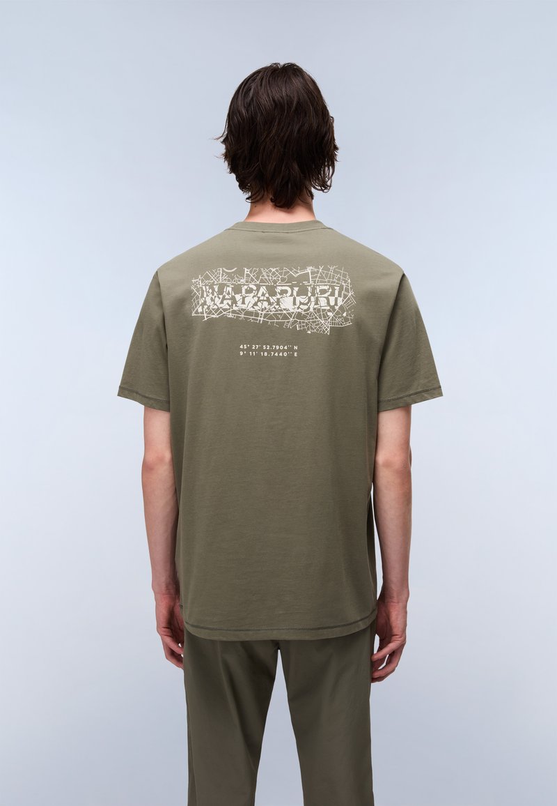 oliwkowo-zielona bawełniana koszulka z graficznym wzorem zawierającym współrzędne z tyłu, krótki rękaw i prosty krój.