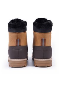 Braune und schwarze Stiefel mit Kunstfellfutter, strukturiertem Obermaterial und Gummisohle. Sie verfügen über ein vertikales Streifen-Detail an der Ferse.