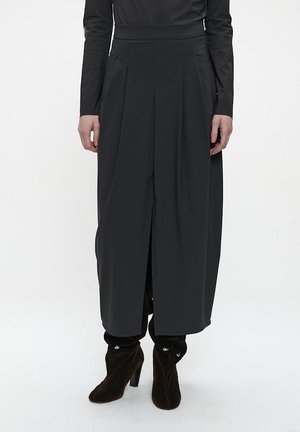 Schwarze, weit geschnittene Hose mit hoher Taille, ausgestattet mit Falten und Seitenknöpfen. Hergestellt aus glattem Stoff, gestaltet für eine fließende Silhouette.