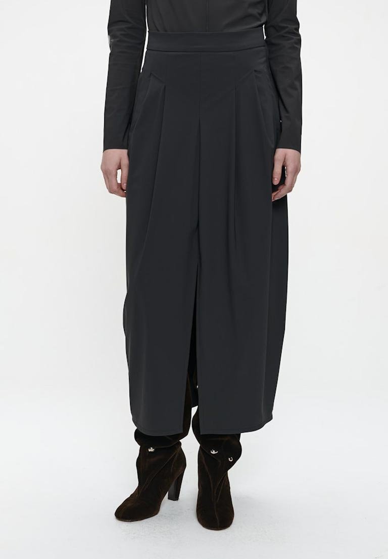Schwarze, weit geschnittene Hose mit hoher Taille, ausgestattet mit Falten und Seitenknöpfen. Hergestellt aus glattem Stoff, gestaltet für eine fließende Silhouette.