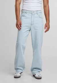 Ljust blå denimjeans med avslappnad passform, fem fickor, bältesloopar och knappstängning. Mjuk textur med synliga sömnadsdetaljer.