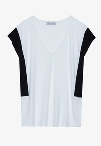 Camiseta blanca de manga corta con un profundo escote en V y mangas negras. Confeccionada en una tela suave, de corte holgado y con un detalle de costura minimalista.