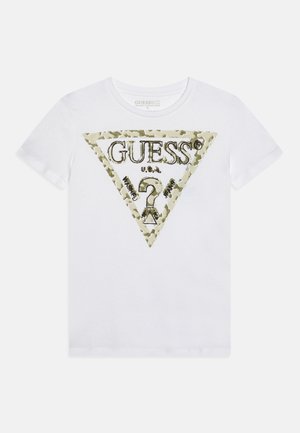 Camiseta blanca de manga corta con un gran logo triangular beige de camuflaje con el texto "GUESS U.S.A" y un símbolo central de signo de interrogación.