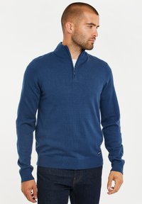 Blauer Strickpullover mit hohem Kragen und Viertel-Reißverschluss. Verfügt über gerippte Bündchen und Saum, aus einem weichen, strukturierten Stoff gefertigt.