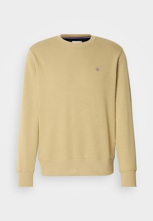 Jasnożółta bluza wykonana z miękkiej bawełny. Posiada okrągły dekolt, długie rękawy oraz małe haftowane logo na piersi.