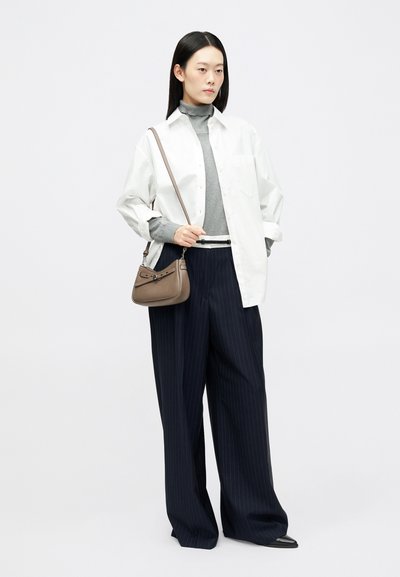 Bežs rokassoma ar siksnu, balta lielizmēra krekls, pelēks kaklasaite un tumši zila svītrainā platā bikses. Gludas tekstūras un strukturēts dizains.