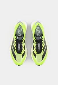 Heldergele hardloopschoenen met zwarte accenten, mesh textuur, gestroomlijnd design en platte veters. Kenmerkt de "ADIZERO" branding op de tong.