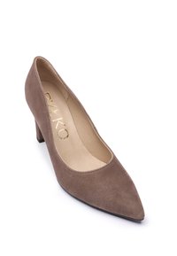 Zapato de tacón alto de ante marrón con diseño de punta afilada, frente bajo y logotipo dorado en la plantilla. Forro interior suave y exterior texturizado.