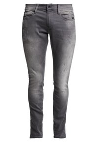 Slim-fit harmaat farkut, joissa on kevyttä kulutusta etupuolen reisissä ja viisi taskua. Napitus vyötäröllä.
