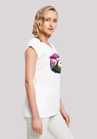 Weißes T-Shirt mit kurzen Ärmeln, das ein farbenfrohes Grafikdesign von Bäumen und Blumen in einem kreisförmigen Muster zeigt, hergestellt aus weichem Baumwollmaterial.