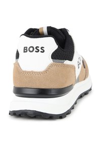 Sko med svart mesh-overdel, beige semsket hæl og hvit mellomsåle. Har 'BOSS' merkevare bak og en teksturert såle.