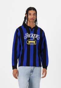 Blå og svartstripet langermet polo skjorte med brodert "JACKER"-logo og gul aksent. Strikket stoff med krage og avslappet passform.