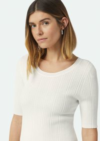 Witte ribgebreide trui met een brede halslijn en korte mouwen. De stof heeft verticale strepen, wat zorgt voor een gestructureerd uiterlijk.