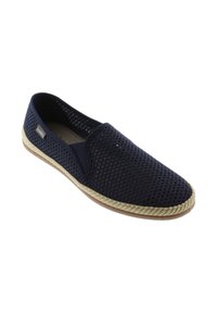 Zapato slip-on de malla azul marino con ribete trenzado beige y suela de goma, con panel lateral elástico y pequeña etiqueta de marca en el costado.