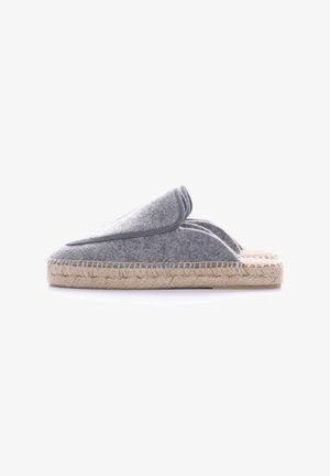 Chaussons gris en feutre avec un large dessus, semelle intermédiaire en corde de jute et détails cousus le long du bord. Dos ouvert pour un enfilage facile.