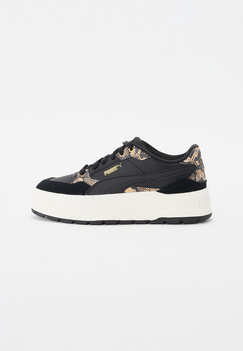 Baskets Puma noires et beiges à motif serpent, semelle blanche épaisse, design à lacets et logo Puma doré sur le côté.
