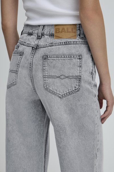 Grijze denim jeans met een losse pasvorm, voorzien van twee achterzakken en een bruine leren patch met het label "BALL" op de tailleband.