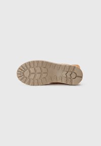 Brown boot with a durable rubber outsole featuring a textured tread pattern for grip. The sole is thick and designed for traction.