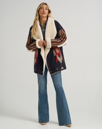 Ullblandet jakke med en kremfarget faux fur-krage, med fargerike stripete ermer og geometriske mønstre i røde og blå toner.