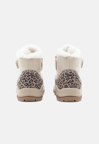 Botine bej la gleznă, cu un panou din imprimeu leopard, margine moale din blană albă și curea cu arici. Talpa din cauciuc texturat oferă aderență.