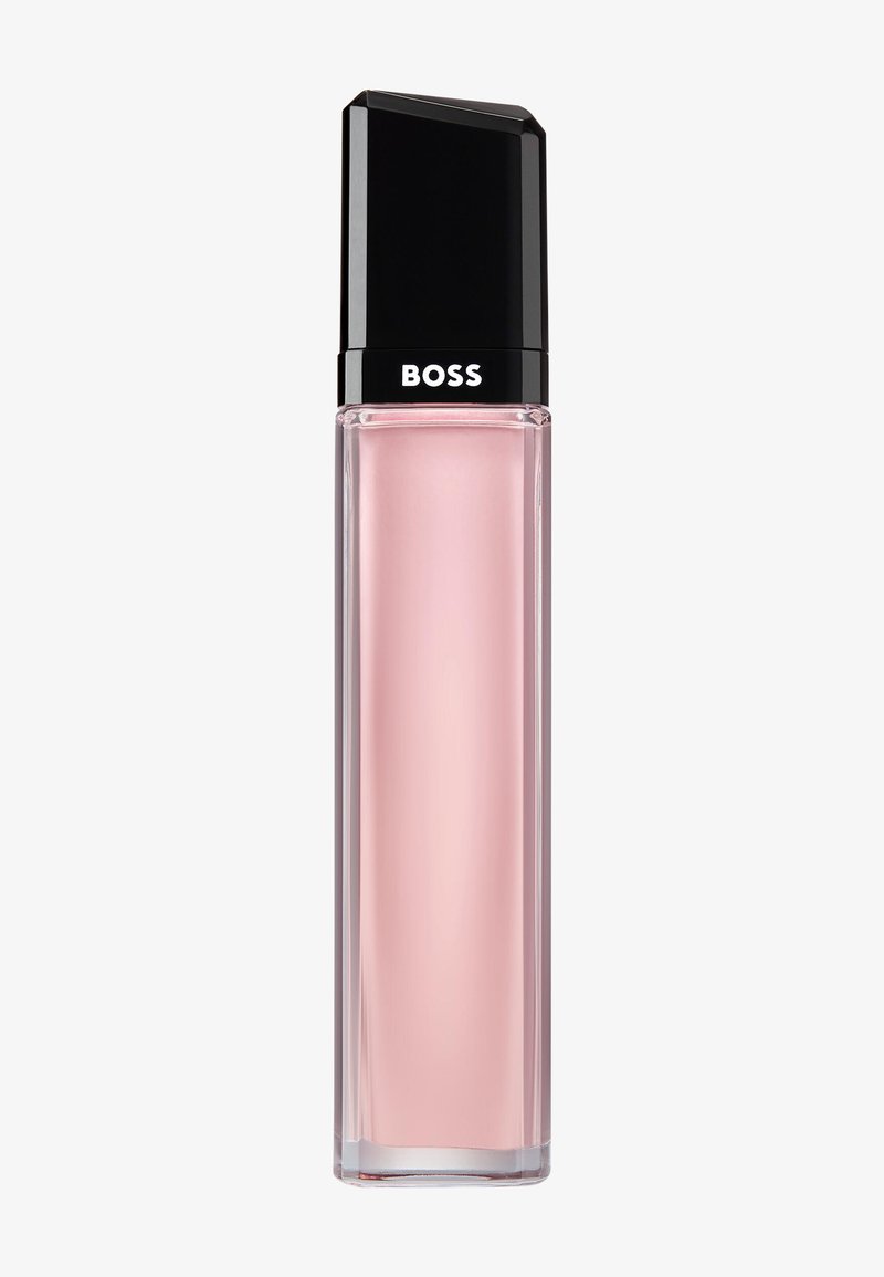 Høj rektangulær glas parfume flaske med lyserød væske og sort låg med teksten "BOSS" på en ensfarvet baggrund.