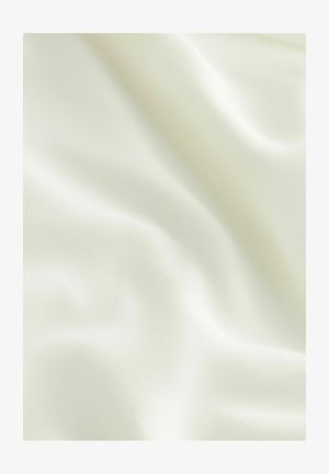 Sileä, kermaisen värinen kangas, jossa pehmeitä, virtaviivaisia laskoksia ja hienovarainen rakenne tasaisen valaistuksen alla.