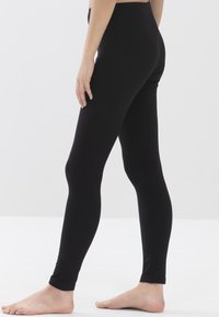 Zwarte leggings van rekbaar materiaal, met een aansluitend ontwerp, gladde textuur en een gladde tailleband die eindigt op enkel lengte.