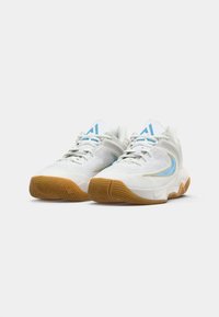 Witte sneakers met een textuur, blauwe accenten en een gumrubberen zool; heeft een vetersluiting en een ronde neus.