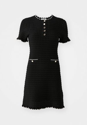 Czarna dzianinowa sukienka z krótkimi rękawami, falbaniastymi brzegami, listwą guzikową oraz dwiema białymi kieszeniami z przodu.