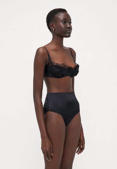 Black satin lingerie set featuring a lace-trimmed bra with underwire and high-waisted matching panties. Smooth texture and minimalist design.