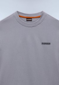 Γκρι βαμβακερό φούτερ με στρογγυλή λαιμόκοψη, με πορτοκαλί εσωτερική επένδυση στον γιακά και μικρό μαύρο λογότυπο στο στήθος. Λείο ύφασμα, casual σχεδιασμός.