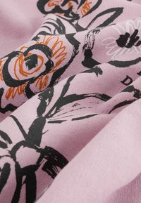 Tessuto a motivi floreali con base rosa e disegni neri e arancioni, texture liscia e morbida caduta.