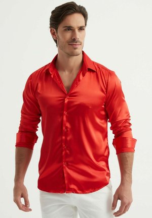 Chemise en satin rouge à manches longues, avec une coupe ajustée et des poignets retroussés. Sa texture lisse et sa finition brillante améliorent son apparence.